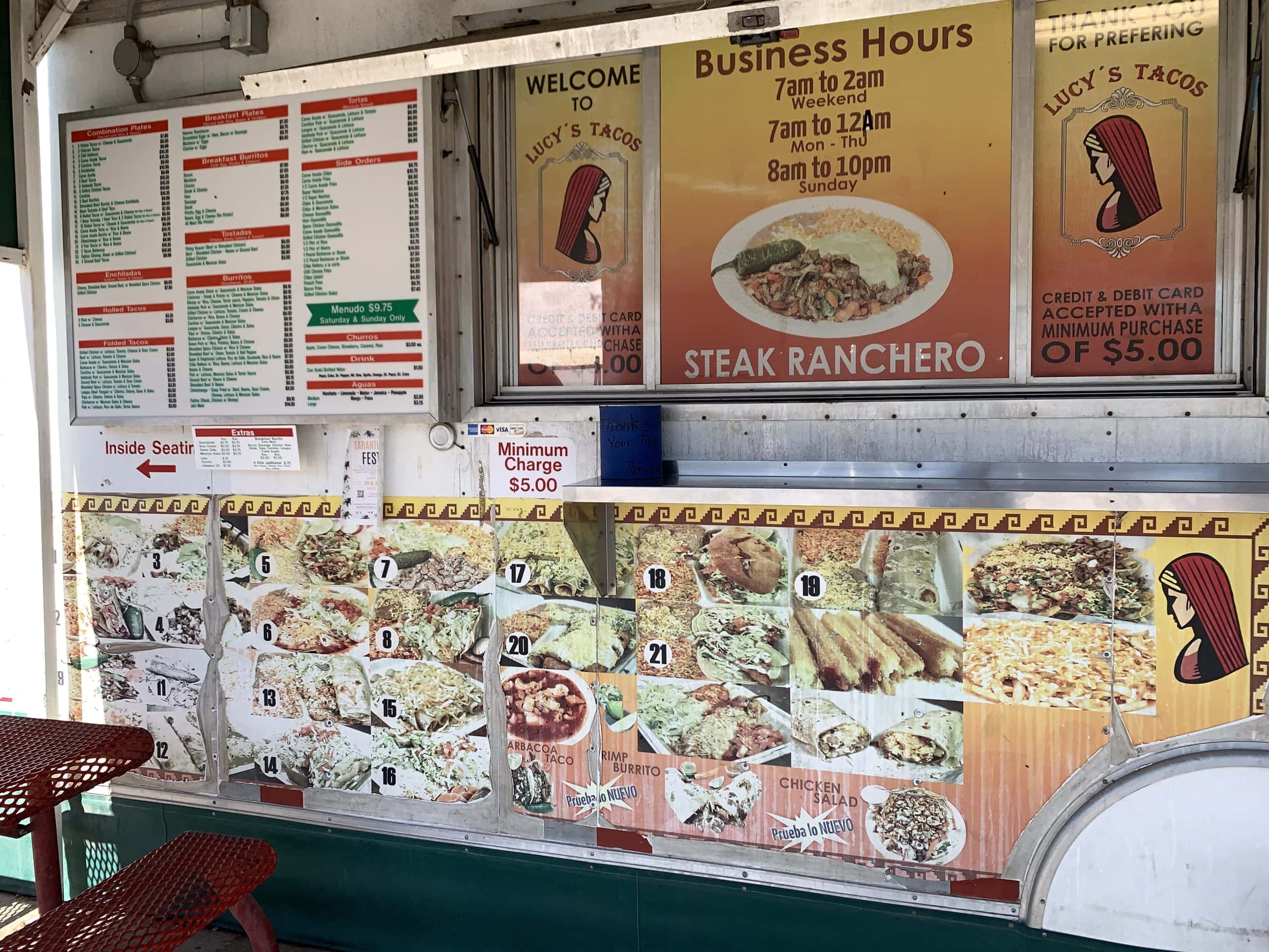 A mexican food stand with a table and chairs.