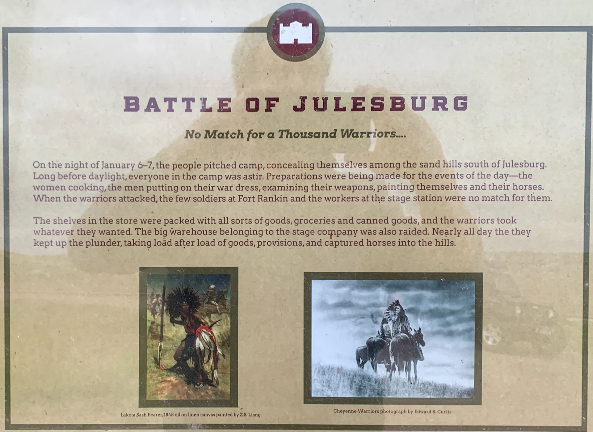 Historic display details the Battle of Julesburg with two images: an illustration of a warrior on horseback and a photograph of Native American riders. Text describes the 1865 event and the conflict's context.