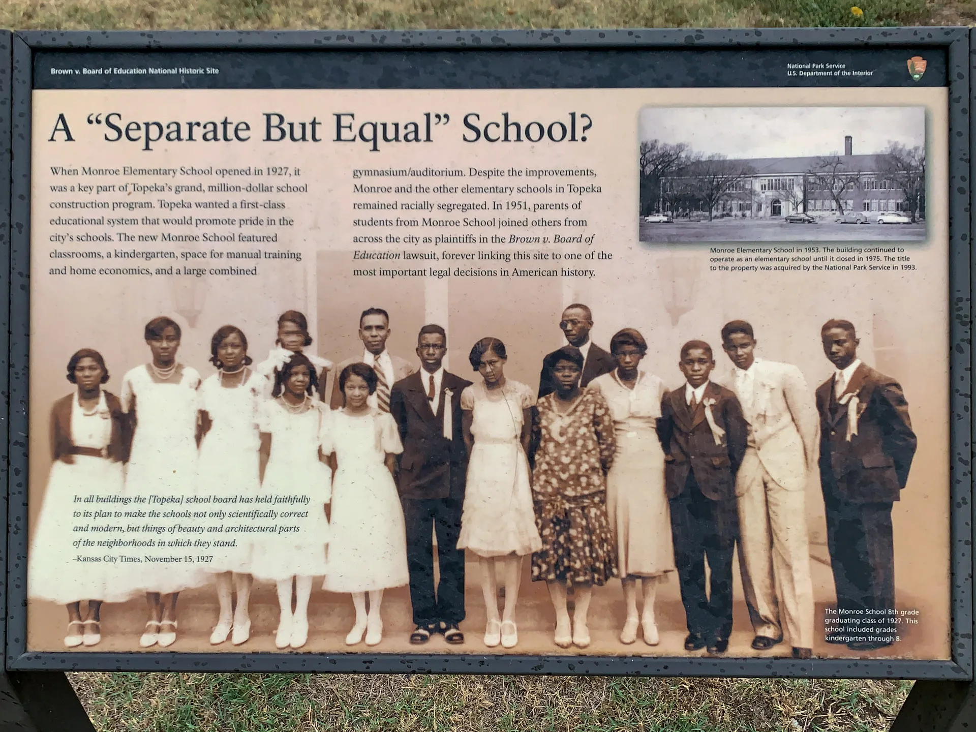 A historical plaque titled "A 'Separate But Equal' School?" with a sepia-toned group photo of 13 African American students and a teacher in formal attire. The plaque discusses Monroe Elementary School and its role in the Brown v. Board of Education case, highlighting segregation.