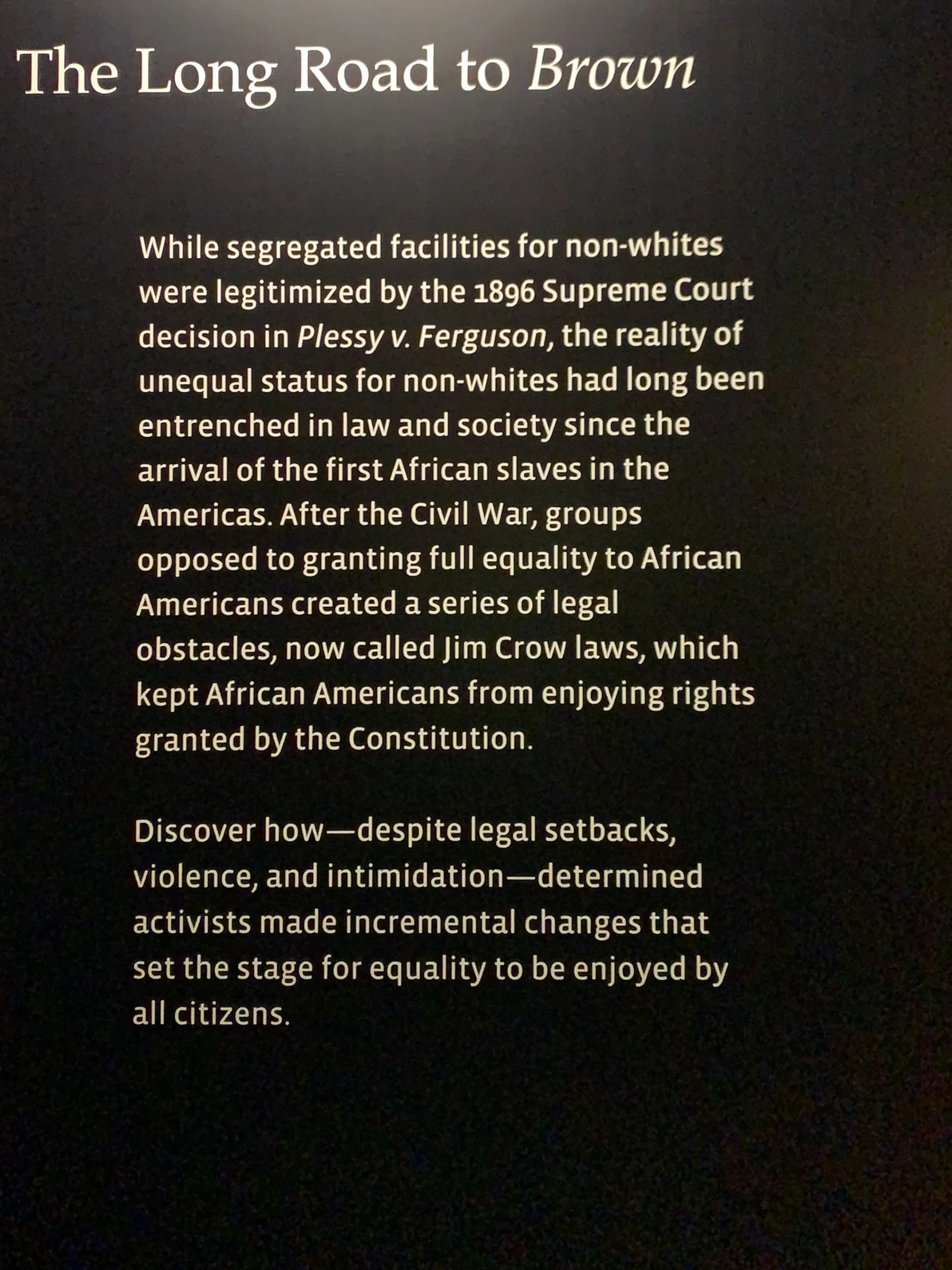 Black text on a dark background titled "The Long Road to Brown" discusses historical legal setbacks for African Americans post-Plessy v. Ferguson, mentioning Jim Crow laws and the eventual fight for equality despite intimidation and discrimination.