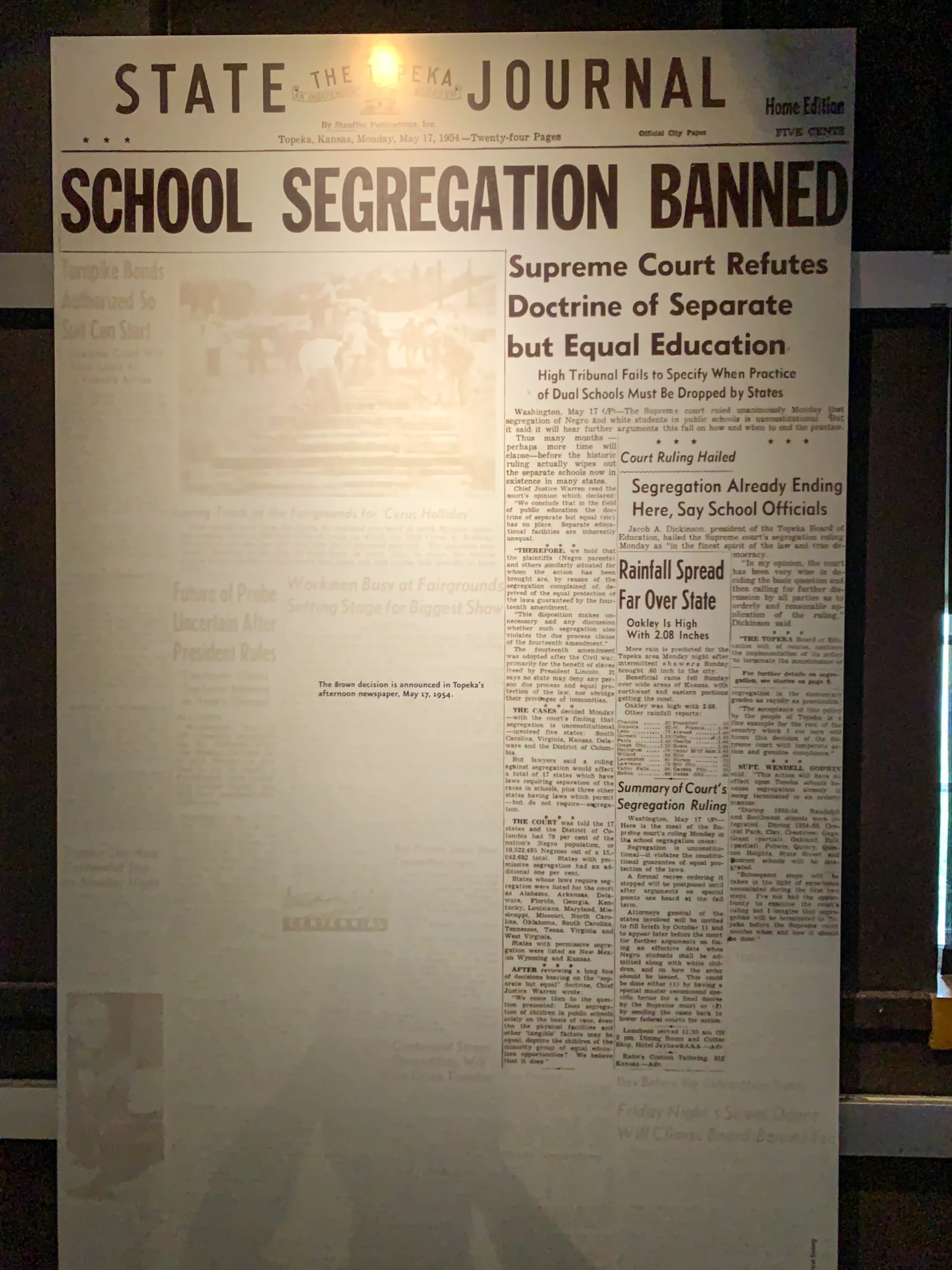Front page of The Topeka State Journal with the headline "School Segregation Banned." The article discusses the Supreme Court's refutation of the "separate but equal" doctrine, emphasizing changes in school segregation policies. The page includes additional smaller articles and images.