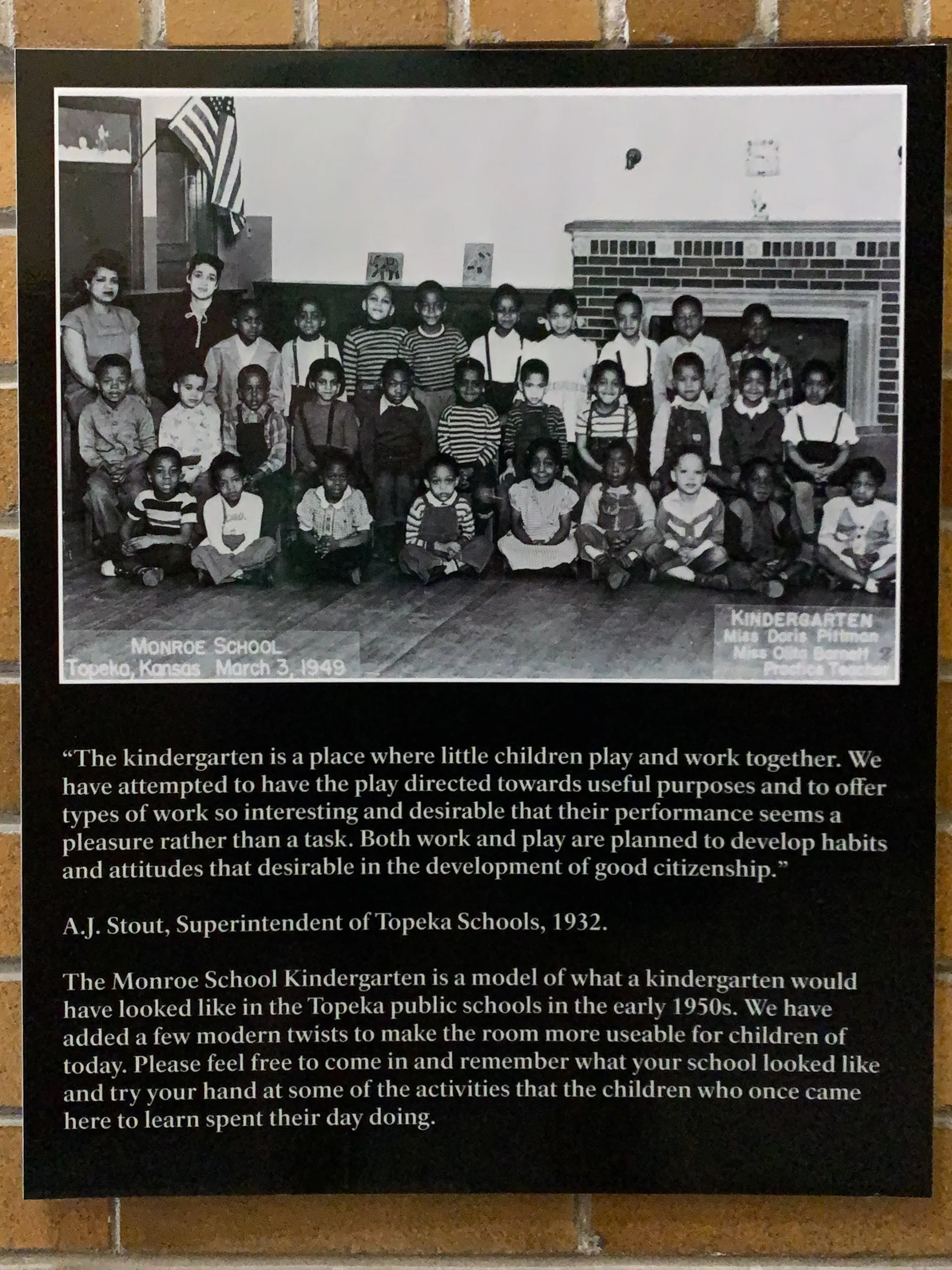 A black and white photo shows a diverse group of young children sitting and standing in three rows inside a classroom at Monroe School, Topeka, Kansas, dated March 3, 1949. The accompanying text describes the importance of play in early education and its role in developing good citizenship.