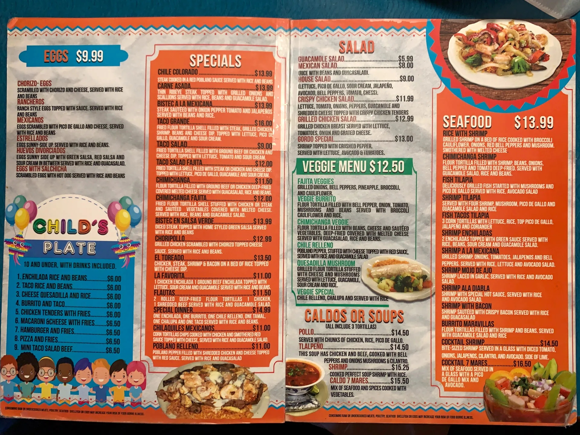 A colorful restaurant menu with three sections: "Eggs $9.99," "Specials," "Seafood $13.99," "Salad," "Veggie Menu $12.50," and "Caldos or Soups." Decorative images include balloons, cartoon children, and food dishes such as salads and seafood. Prices and detailed descriptions fill the pages.
