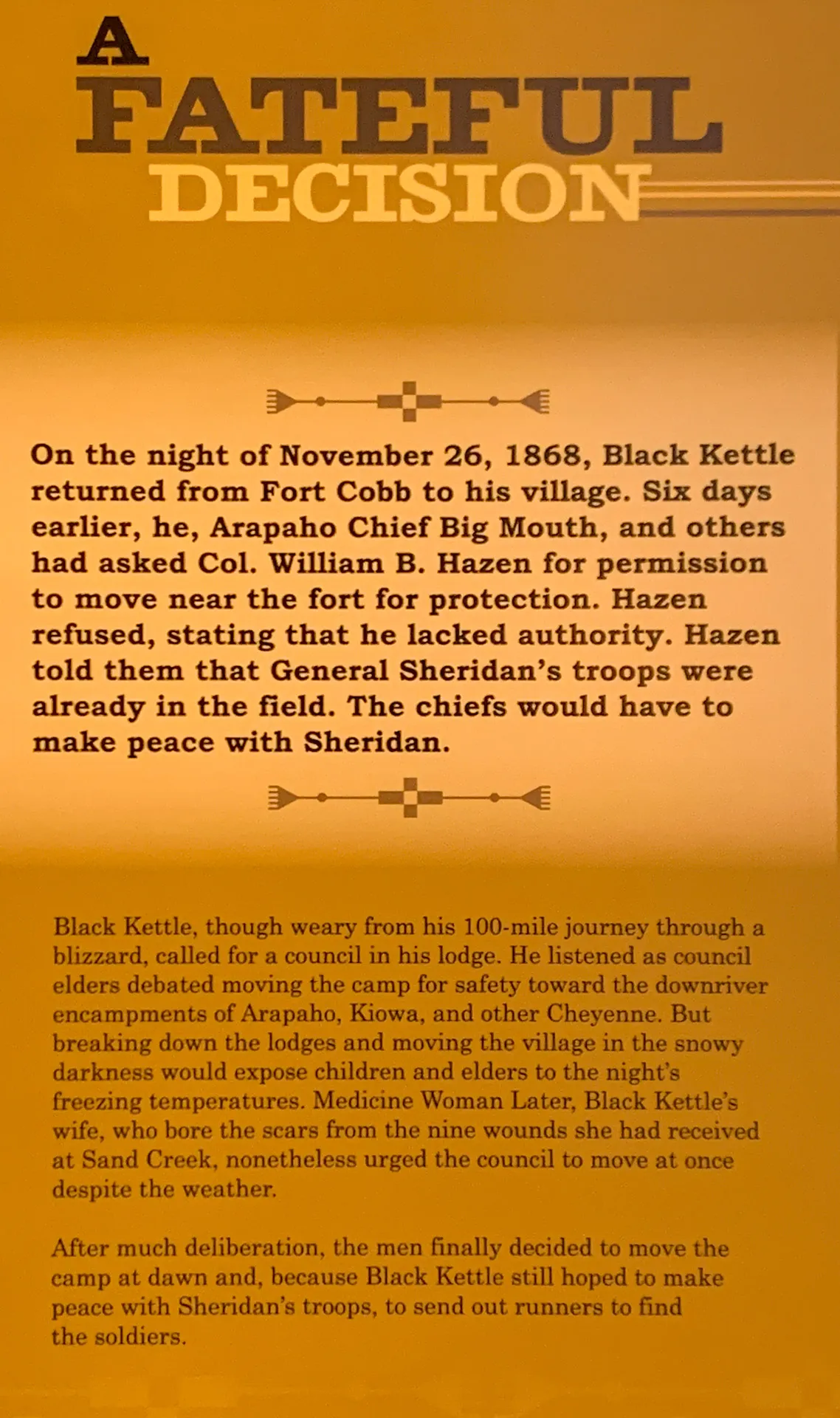A sign titled "A Fateful Decision" with text detailing an event from November 26, 1868, involving Black Kettle seeking protection from General Sheridan’s troops near Fort Cobb. The sign mentions harsh winter conditions and the decision made to camp at nearby ravines for protection.
