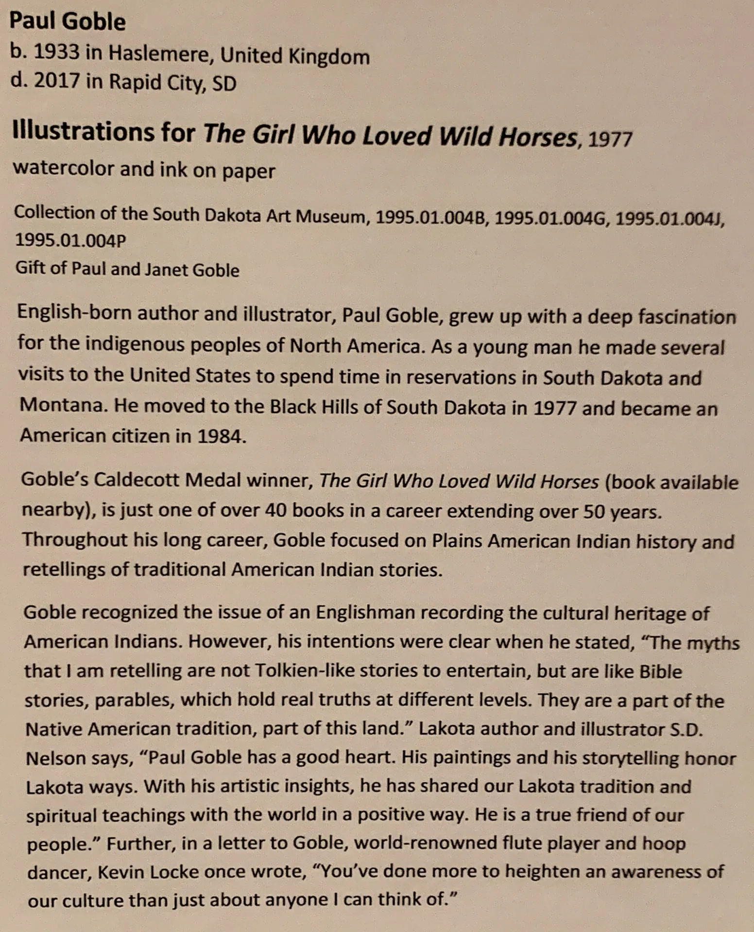 Text description of an exhibit display about Paul Goble, born 1933 in United Kingdom, and died 2017 in South Dakota. It covers his illustration work, specifically "The Girl Who Loved Wild Horses" from 1977, his life journey, influences, and recognition, including a Caldecott Medal.