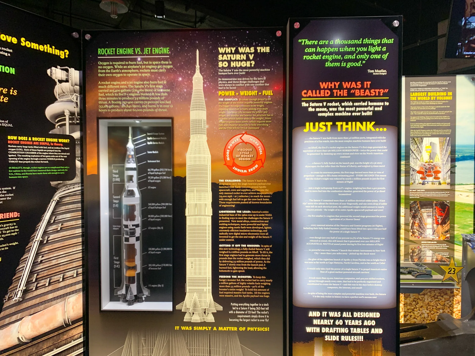 Exhibit panels detail the Saturn V rocket, highlighting its size, power, and design. A cross-section diagram shows the internal structure. Text explains the rocket's engineering and historical significance. Bright colors and bold texts emphasize key points about its massive size and capabilities.