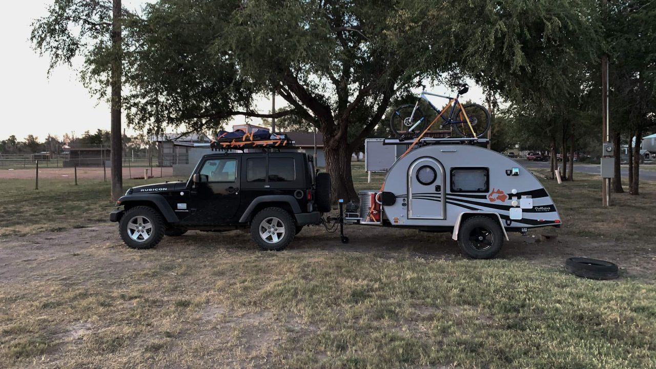 A jeep with a camper trailer attached to it at Holly City Park & Ball Field.