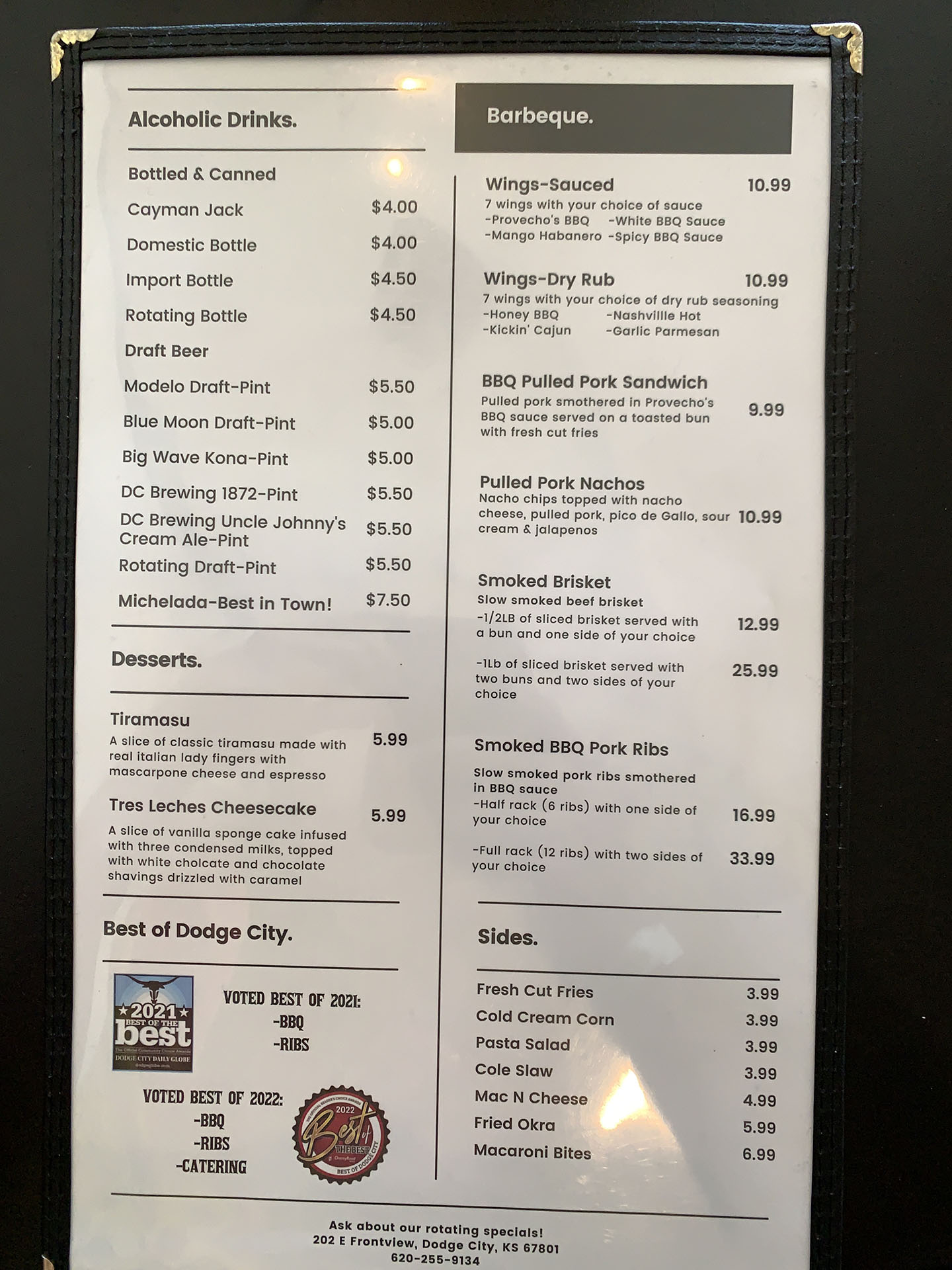 Menu offering alcoholic drinks and barbeque dishes including bottled and canned drinks, draft beer, various BBQ items like wings and pulled pork sandwich, smoked meats, and sides like fries and coleslaw.
