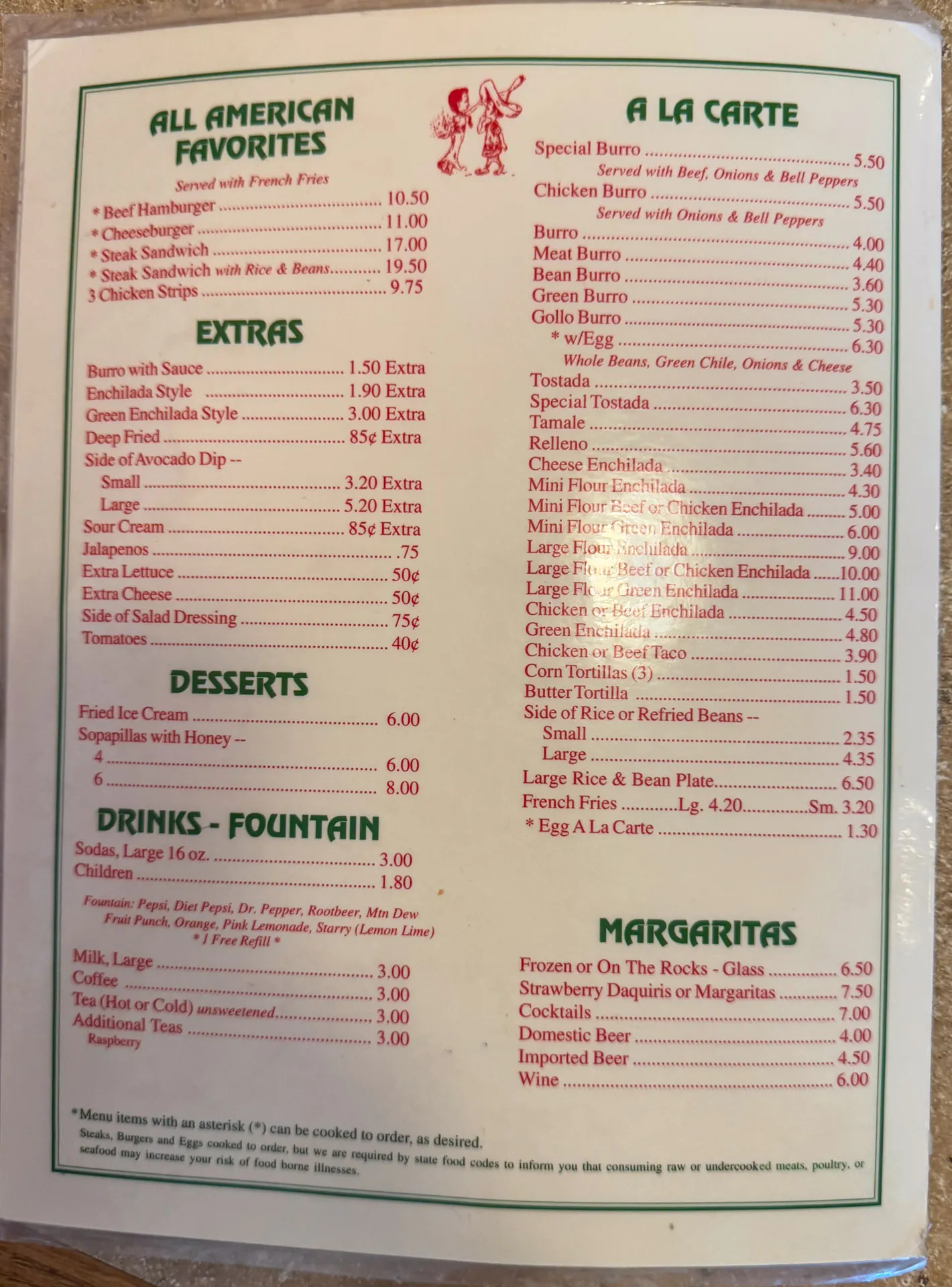 A menu displaying various food and drink options. Categories include All American Favorites, Extras, Desserts, Drinks - Fountain, A La Carte, and Margaritas. Prices are listed next to each item. The menu features a festive border and a small graphic of a red sombrero and a cactus.