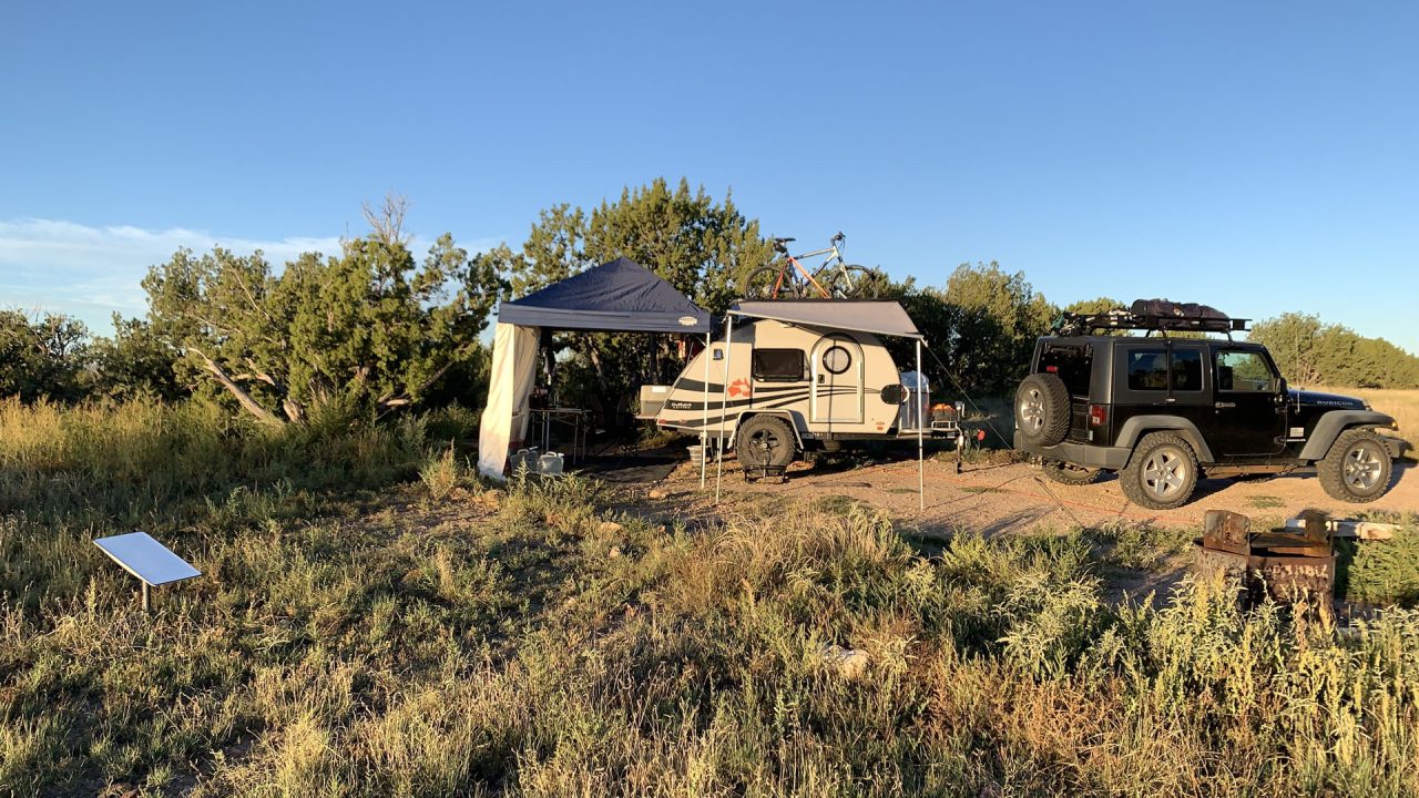 A jeep parked next to a camper in Comanche National Grasslands.